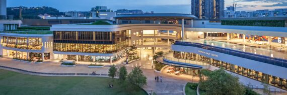 A two-level conference center at dusk overlooking a greensward.